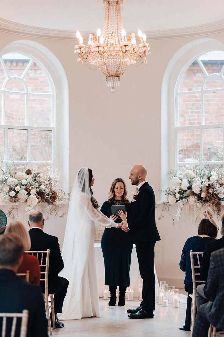 White ceremony room at Iscoyd Park is ideal for beautiful winter wedding days with white flower decor 