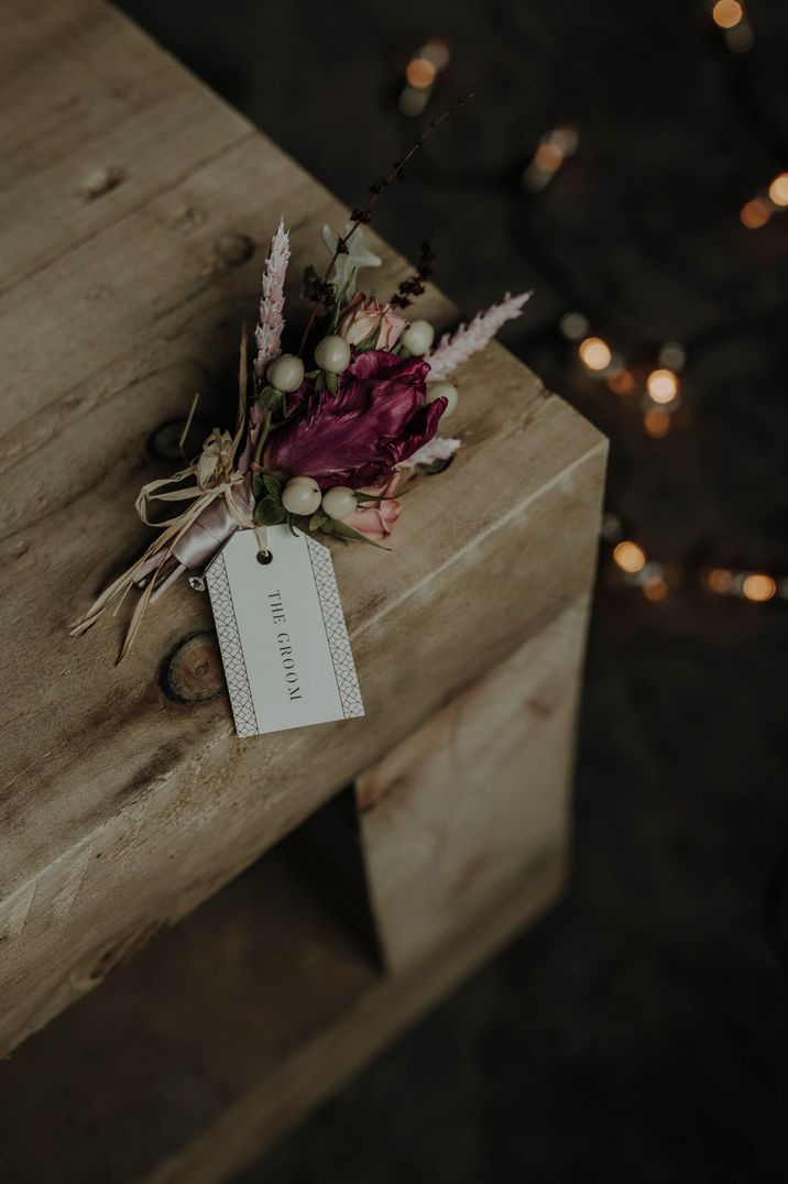 Fresh and dried flower buttonhole with dried grasses, berries and pink flower 