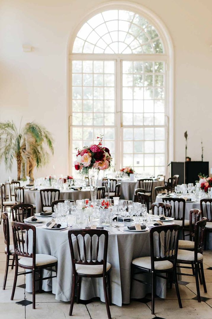 Neutral wedding tablescape at Kew Gardens with grey tablecloths, large colourful floral arrangements 