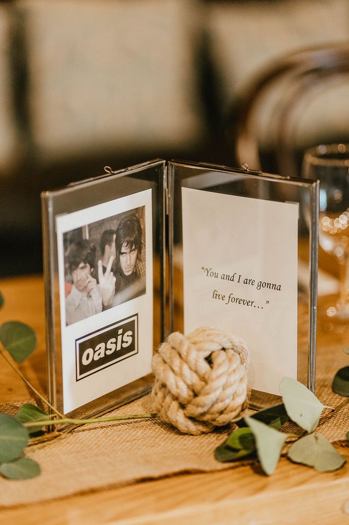 Clear double photo frames for table names based on famous bands the couple loves with a picture of the band and a lyric 