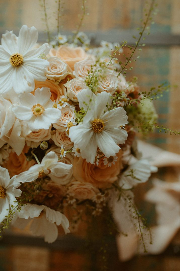 A pink and white wedding flower bouquet with roses and cosmos 