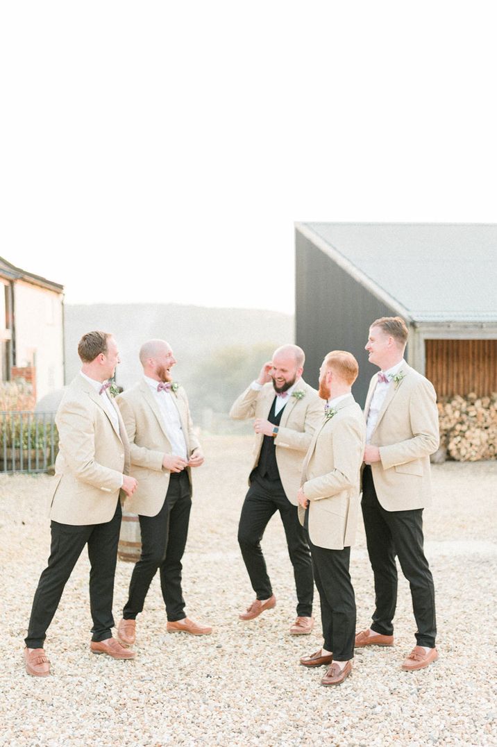 Groom and groomsmen in white wedding suits 