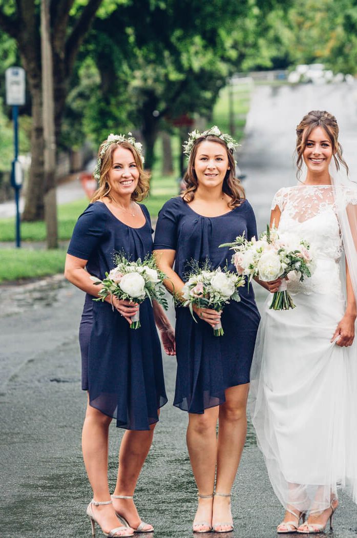 Brides wearing short navy bridesmaid dresses with short sleeves and asymmetrical hemline | French Connection Dresses | Devin Ainslie Photography