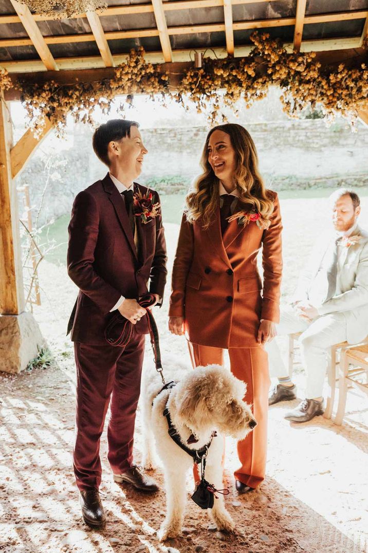 Newlyweds in coordinating suits with dogs at gender neutral wedding