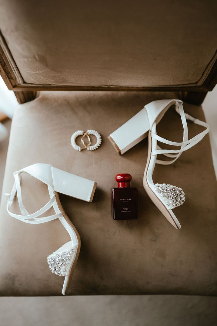 Unique Jo Malone London wedding cologne with the bride's white embellished wedding shoes 