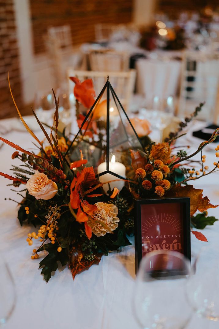 Burnt orange autumnal wedding table centrepiece with geometric lantern 