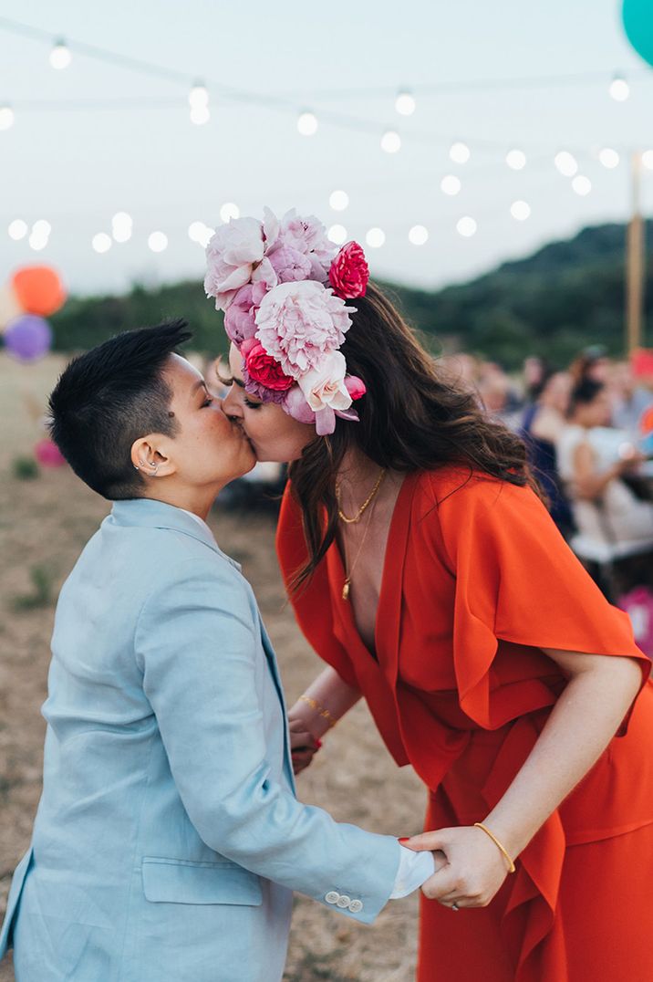 Couple kisses on their wedding day with pink floral crown at LGBTQI+ wedding