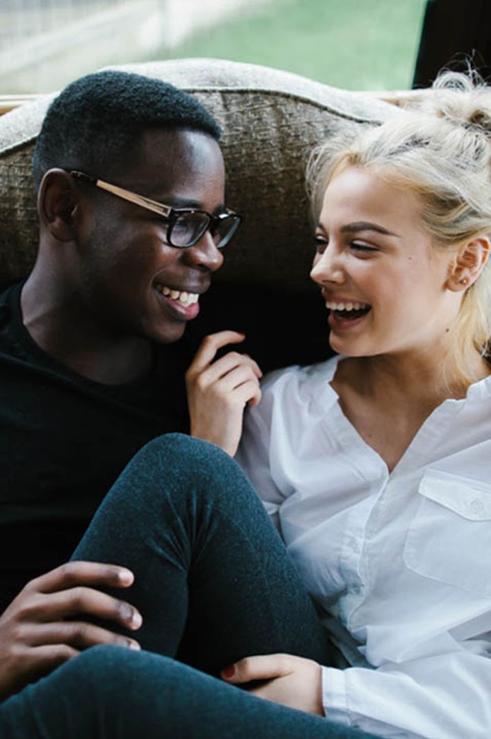 Engaged couple smile at each other 