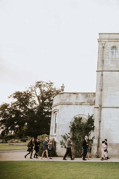 The exterior of Elmore Court and its grounds with guests walking along