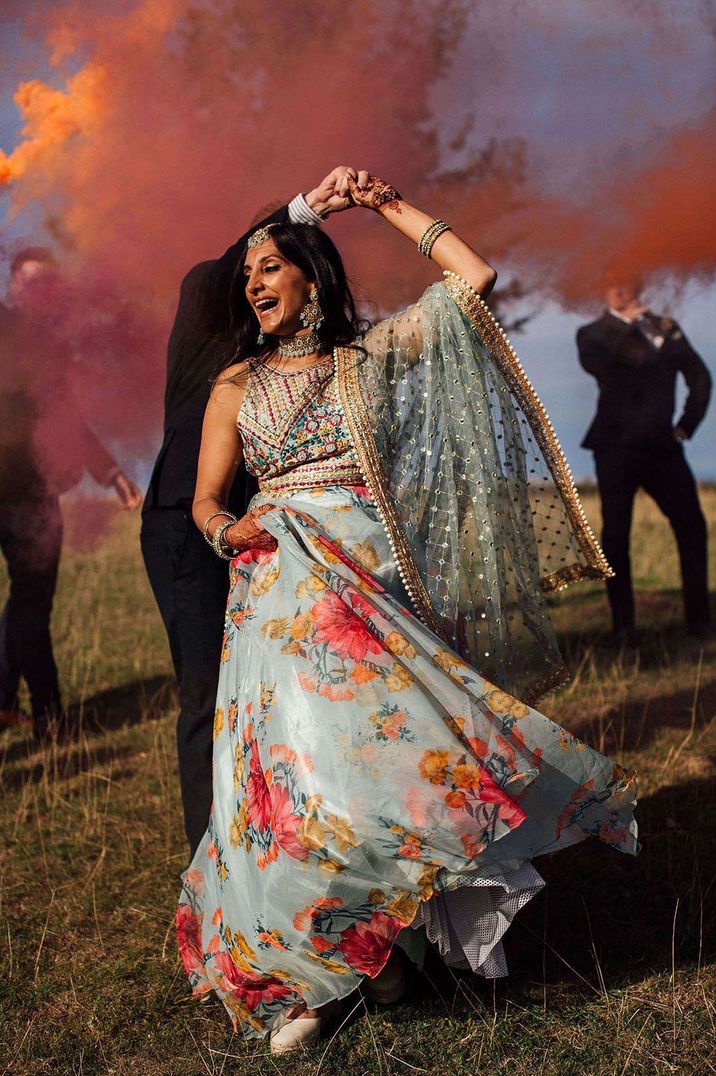 Bride in colourful wedding lehenga dancing in the smokebomb photoshoot - timeline of wedding day 