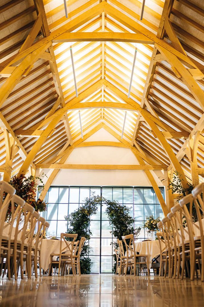 The Post Barn wedding ceremony space with flower columns and stunning large windows 