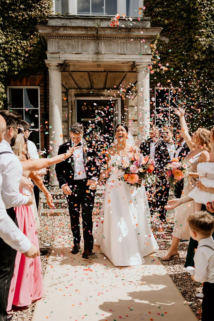 Colourful pink, green and white confetti moment for bride and groom at Wootton Hall wedding venue 