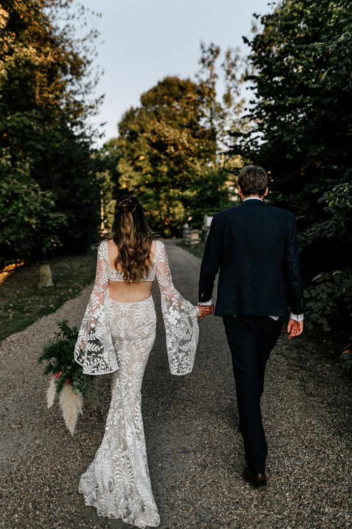 Bride in a lace boho wedding dress with bell long sleeve detail