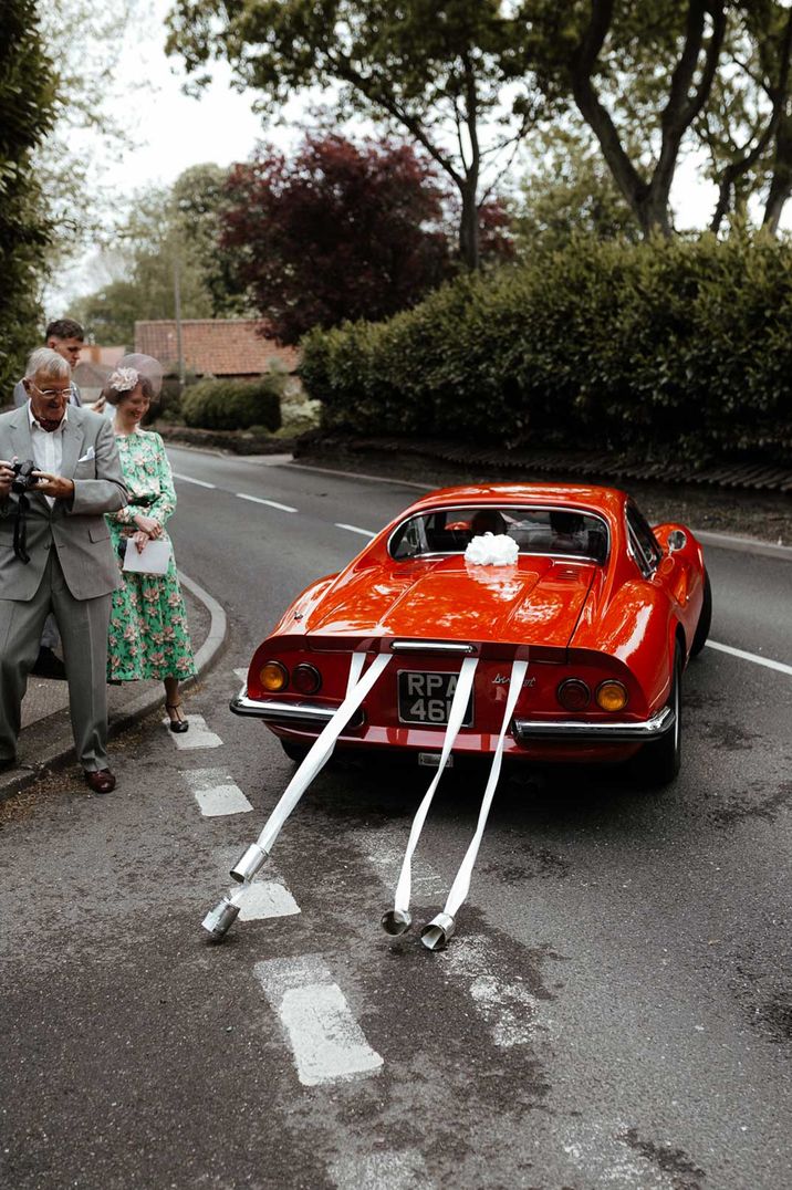 Red vintage wedding car with tin can decorations