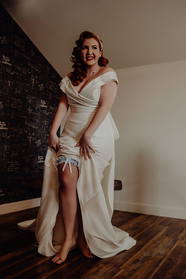 Bride with vintage styling wears white and blue garter with bow detailing