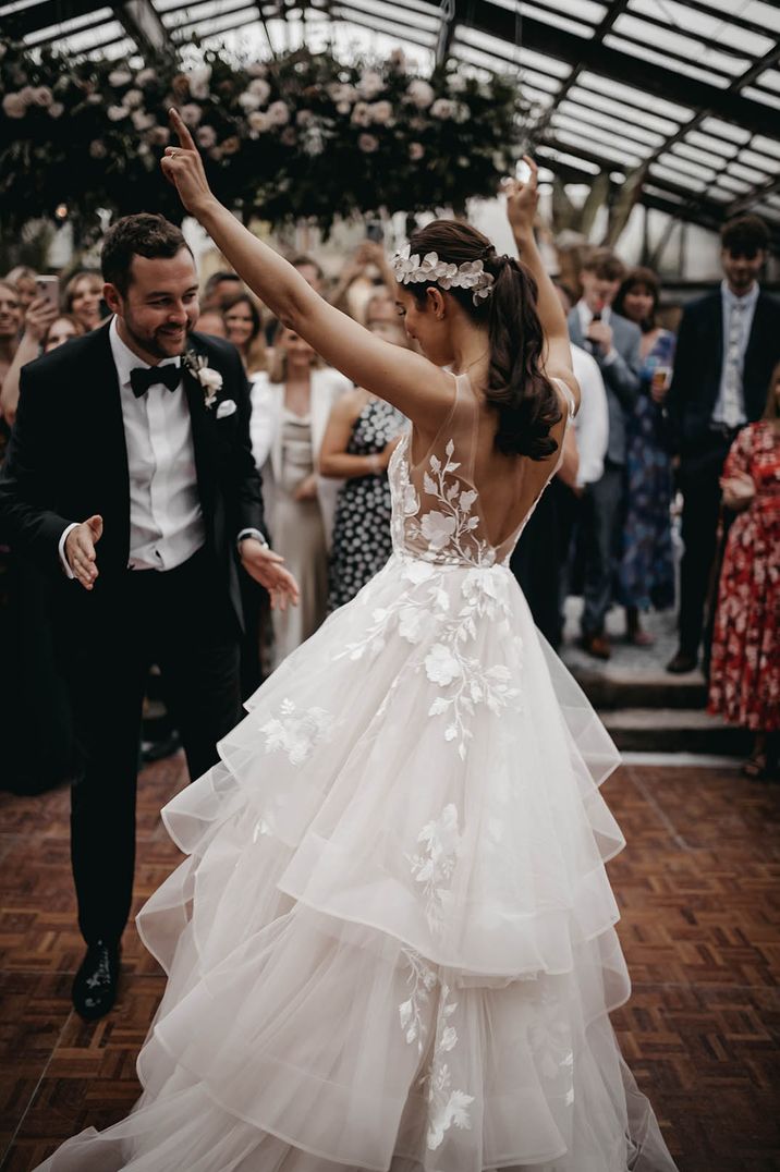 Groom in black tuxedo dancing with the bride in Wtoo by Watters on black and dance floor 