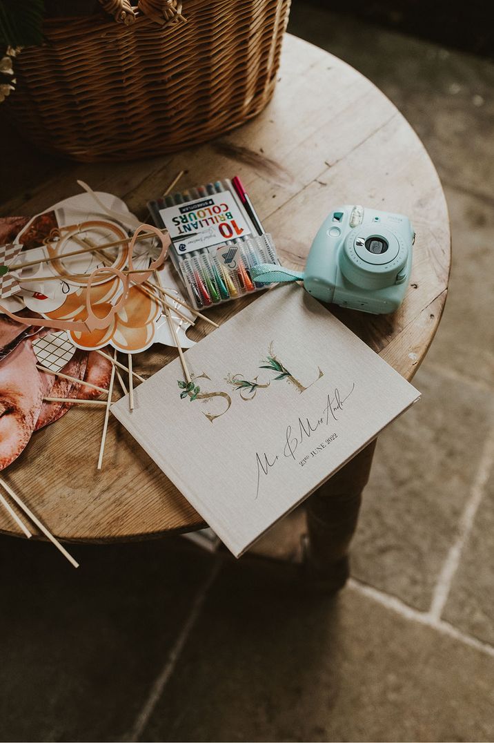 Pack of coloured pens, Instax polaroid camera with lots of props for fun photos and guest book