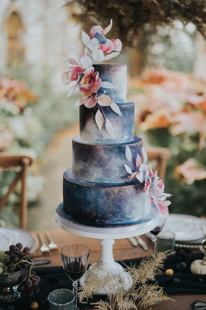 Four tier navy blue and white galaxy luxury wedding cake with hand-crafted leaf decoration 