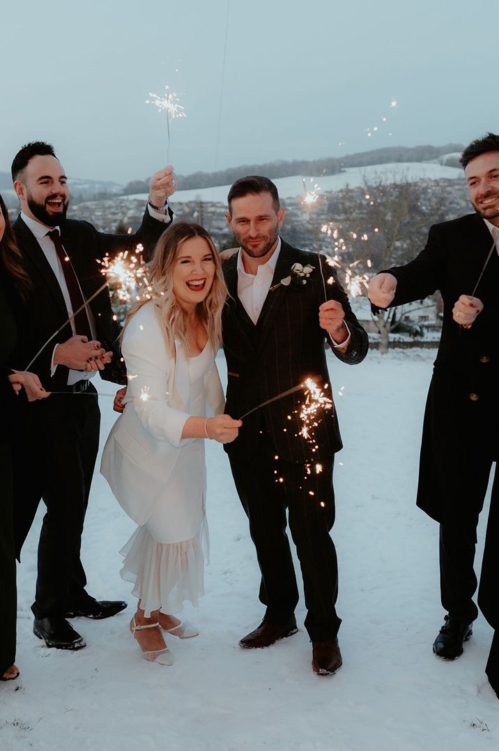 The bride and groom have a romantic sparkler moment with their wedding guests 