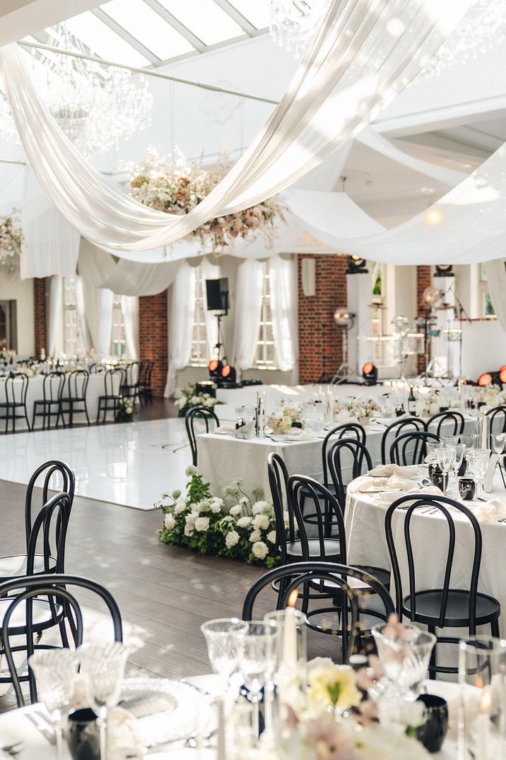 White drapery and white roses contrasting black accent decorations including chairs for monochrome wedding 