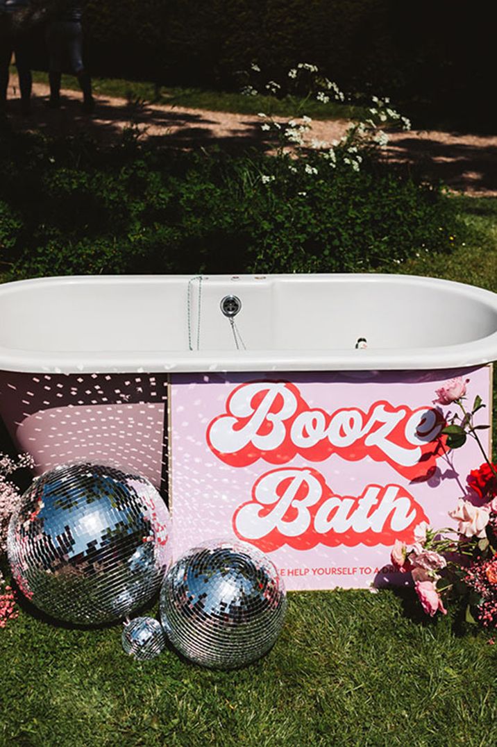 Pink booze bath wedding bar design idea with retro signage and disco balls 