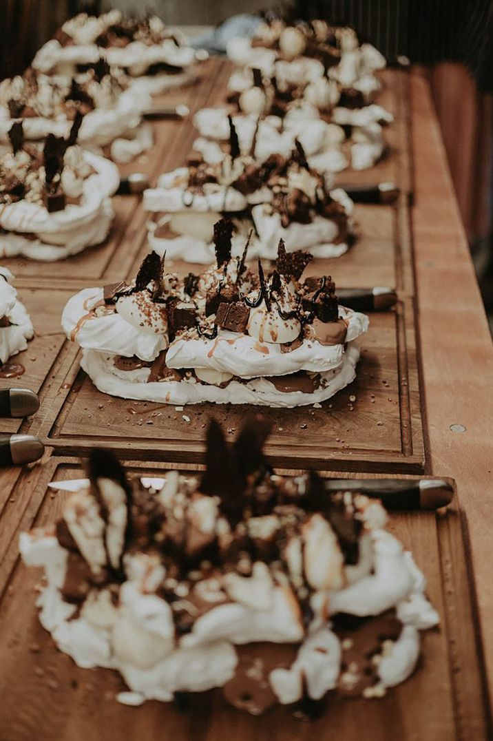 Wedding dessert table with wooden boards for sharing with chocolate brownie pavlova 