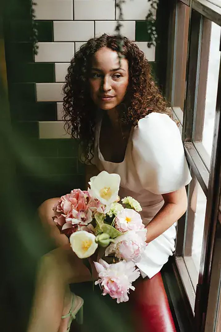 bride with curly hair wearing short wedding dress 