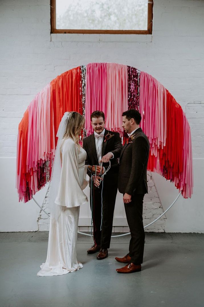 colourful-streamer-backdrop-with-handfasting-ceremony