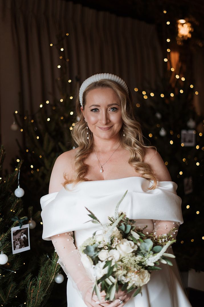 bride-in-pearl-wedding-dress-with-headband-holding-white-bouquet