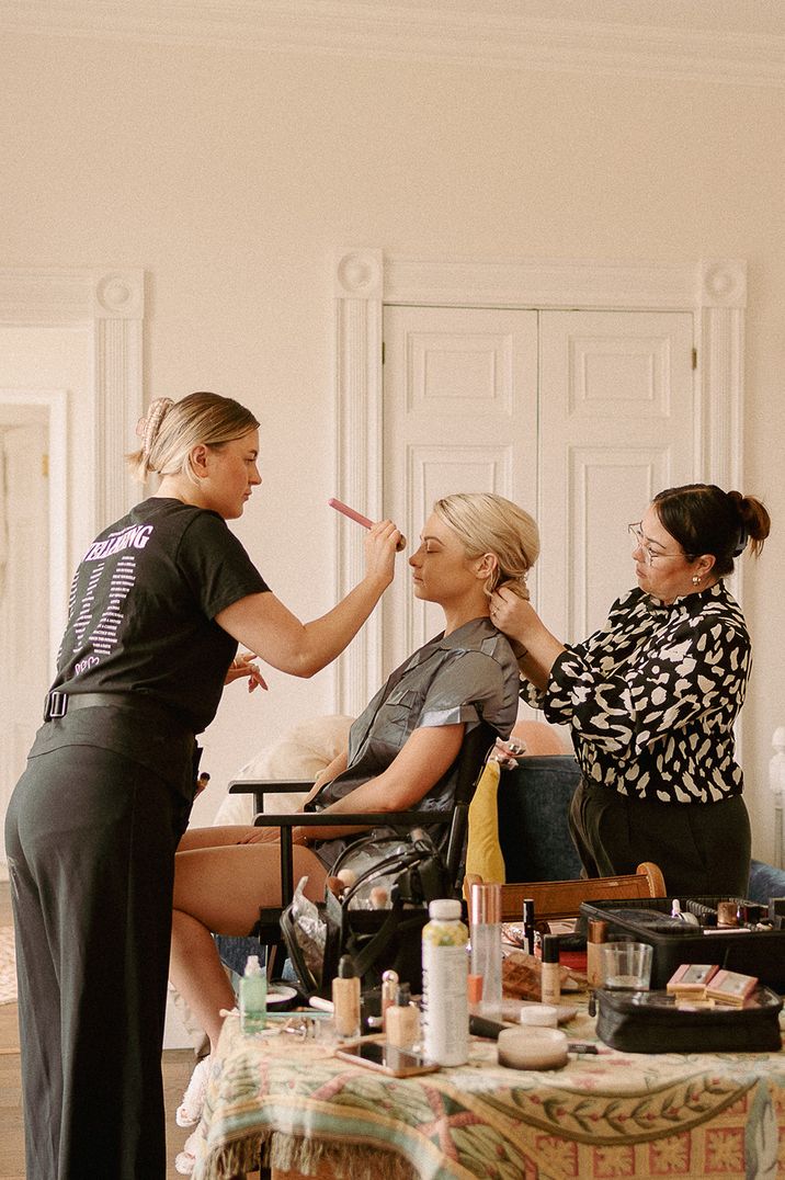 bride-sits-while-hair-and-makeup-artists-get-her-ready