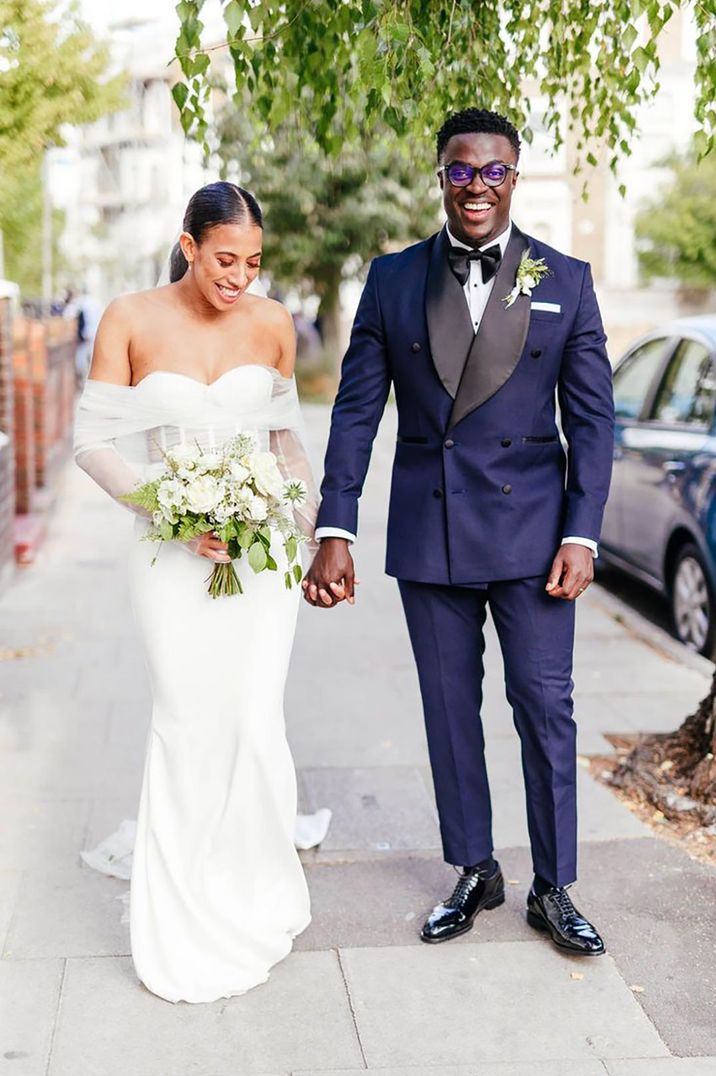 bride-in-off-the-shoulder-wedding-dress-with-groom-in-navy-tuxedo