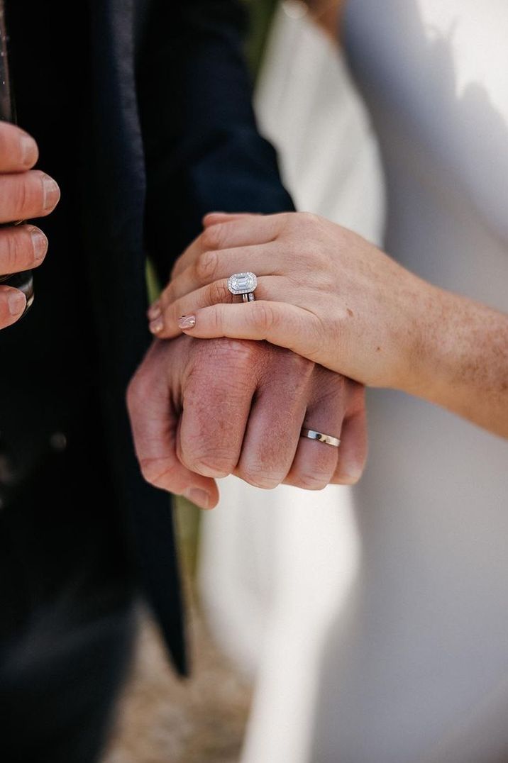 mens plain wedding band with bride wearing big diamond ring