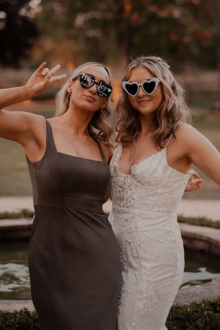 bride posing for picture with wedding guest at black tie wedding