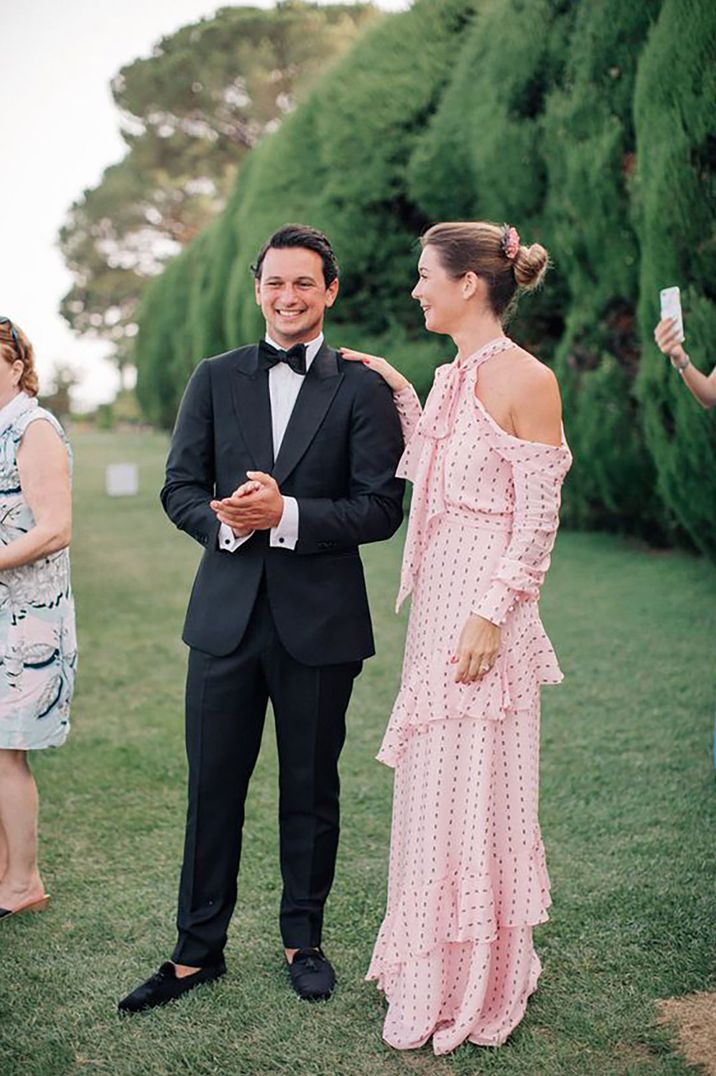 man and woman wedding guest at a black tie wedding wearing a tux and pink maxi dress