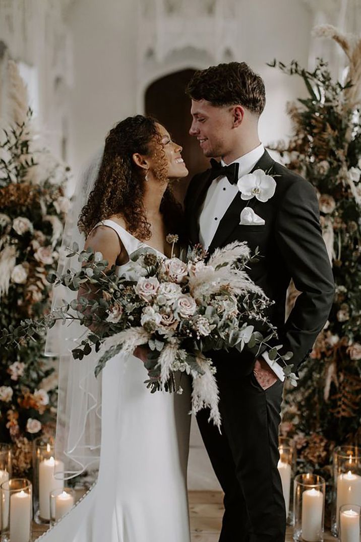 couple wearing black tie attire at the alter on their wedding day