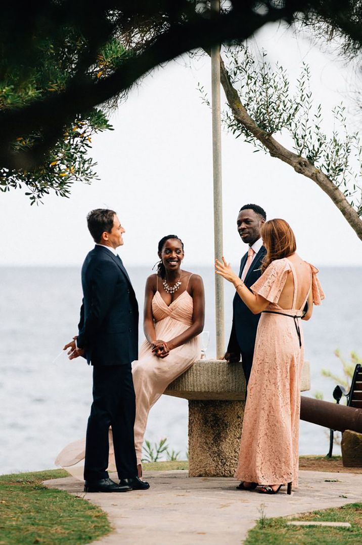 wedding guests wearing black tie/ formal attire for wedding by the sea