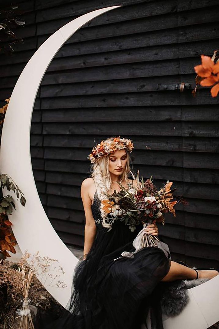 bride wearing black wedding dress with flower crown for halloween themed wedding