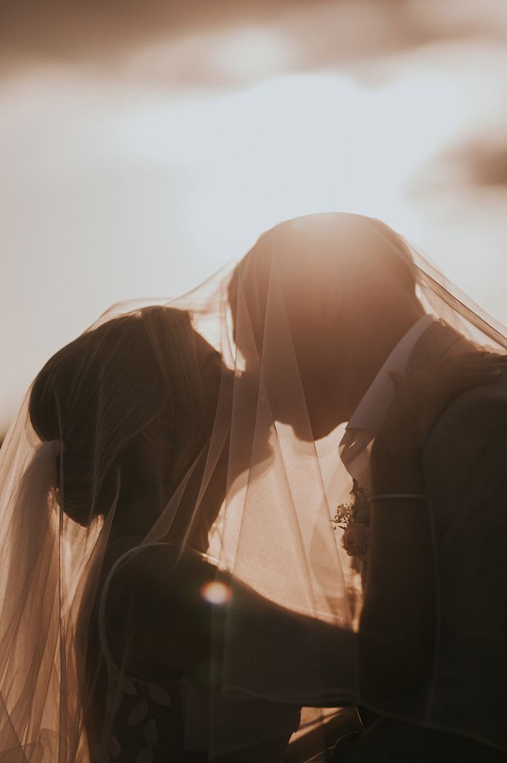 bride-and-groom-kissing-under-bride-wedding-veil