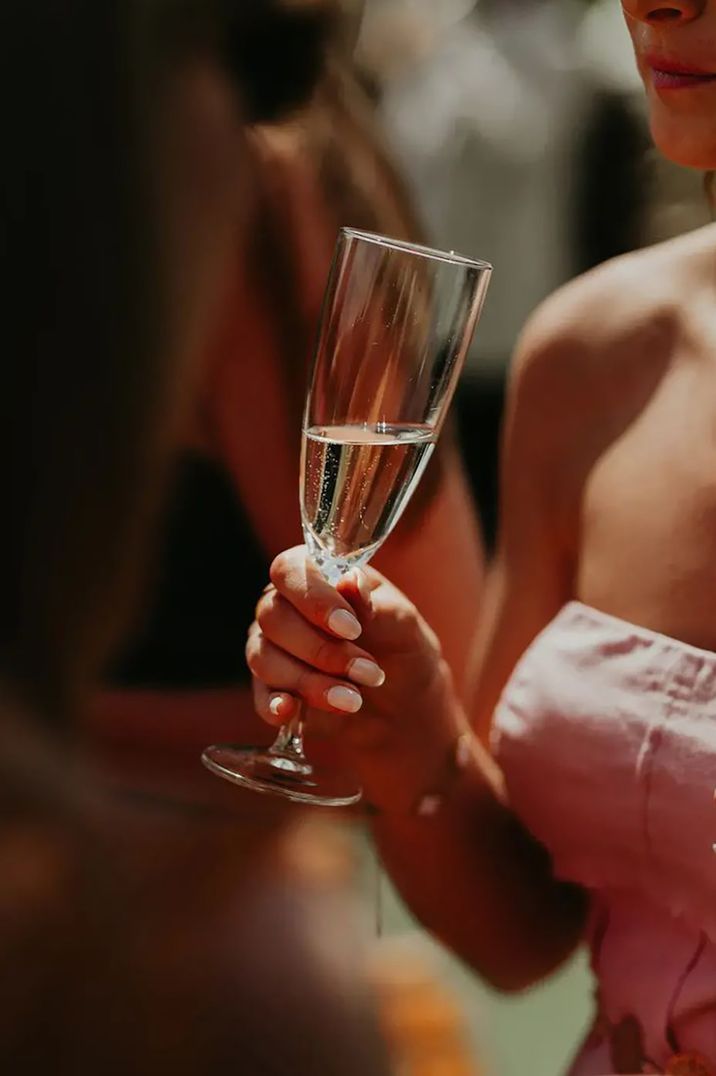 wedding-guest-holding-glass-of-champagne