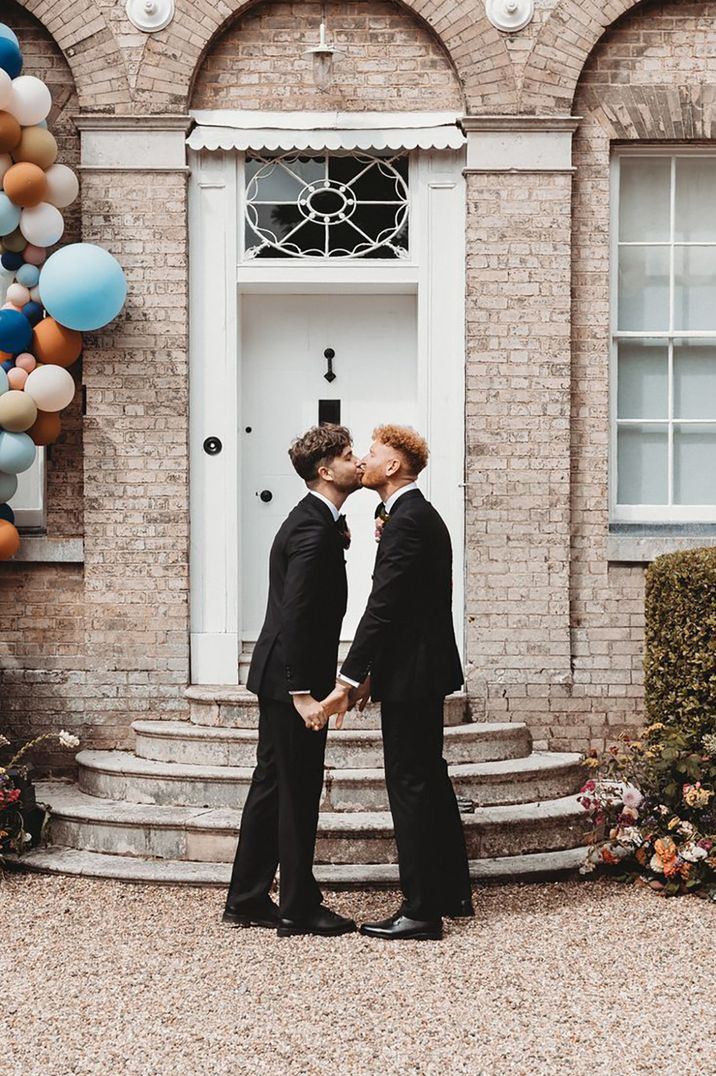 two-grooms-kiss-at-country-house-wedding