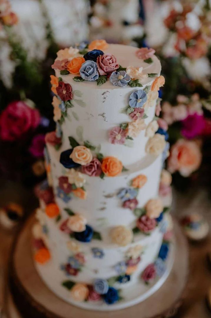 Three tiered iced wedding cake with spring flower icing decorations