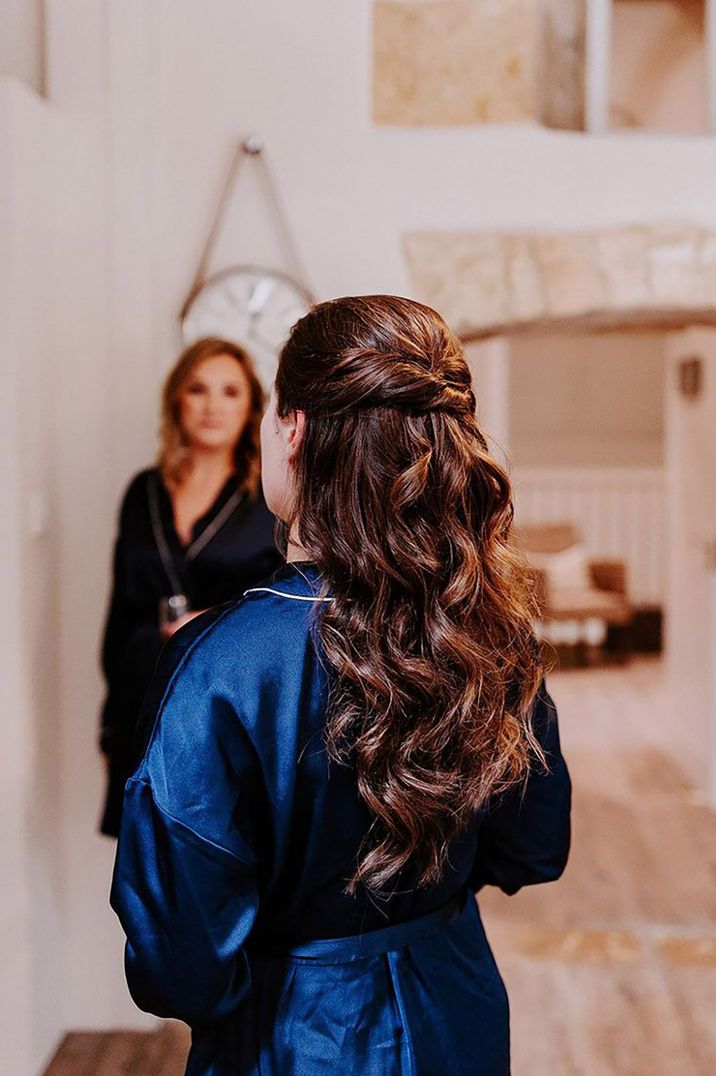 bride wearing dark blue satin bridal robe on wedding morning