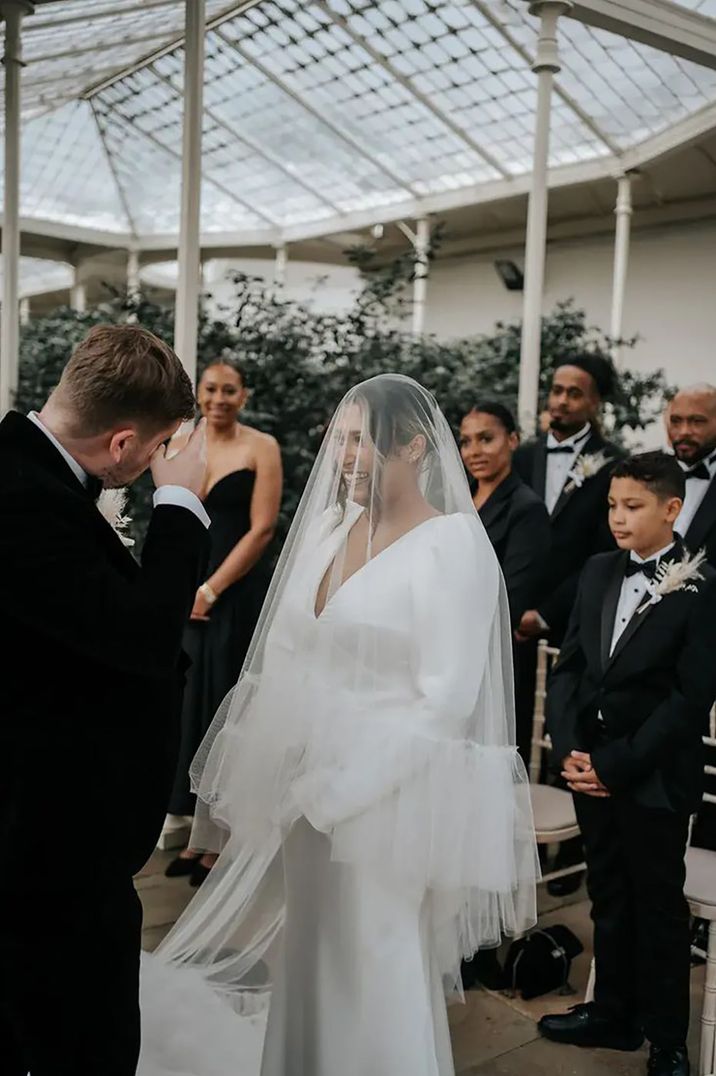 bride and groom at altar with guests in black tie dress code