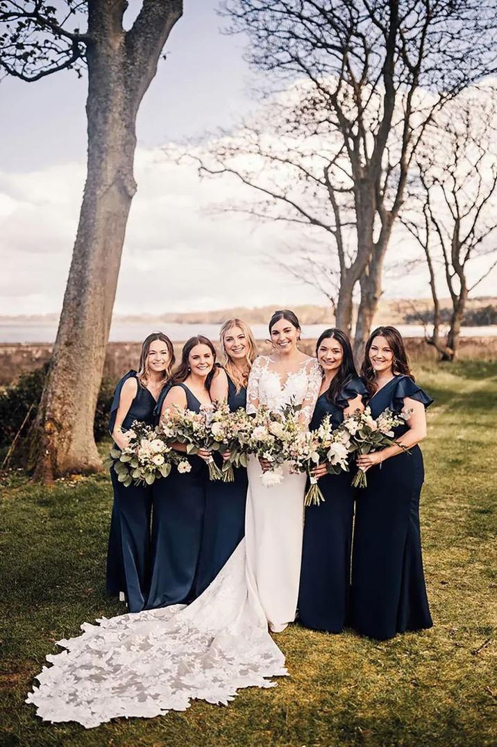 bride with bridesmaids wearing navy blue bridesmaid dresses