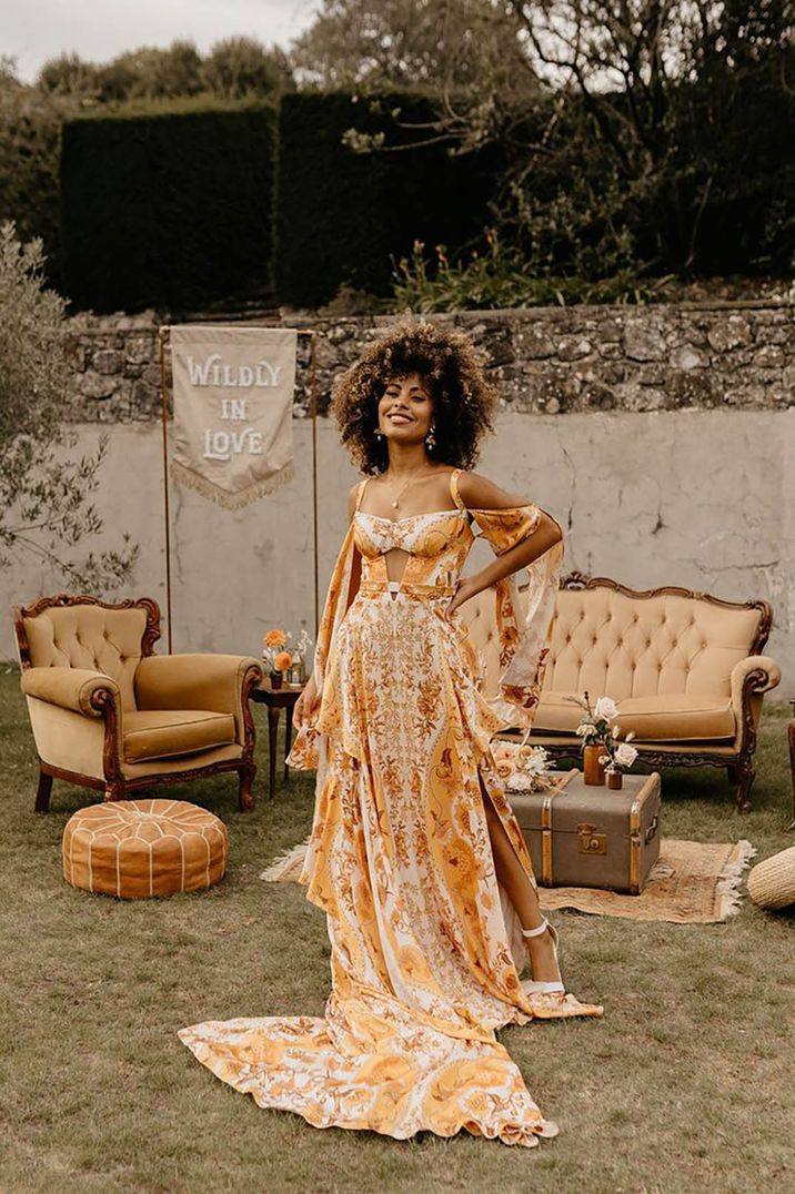 bride wearing orange and yellow coloured patterned wedding dress