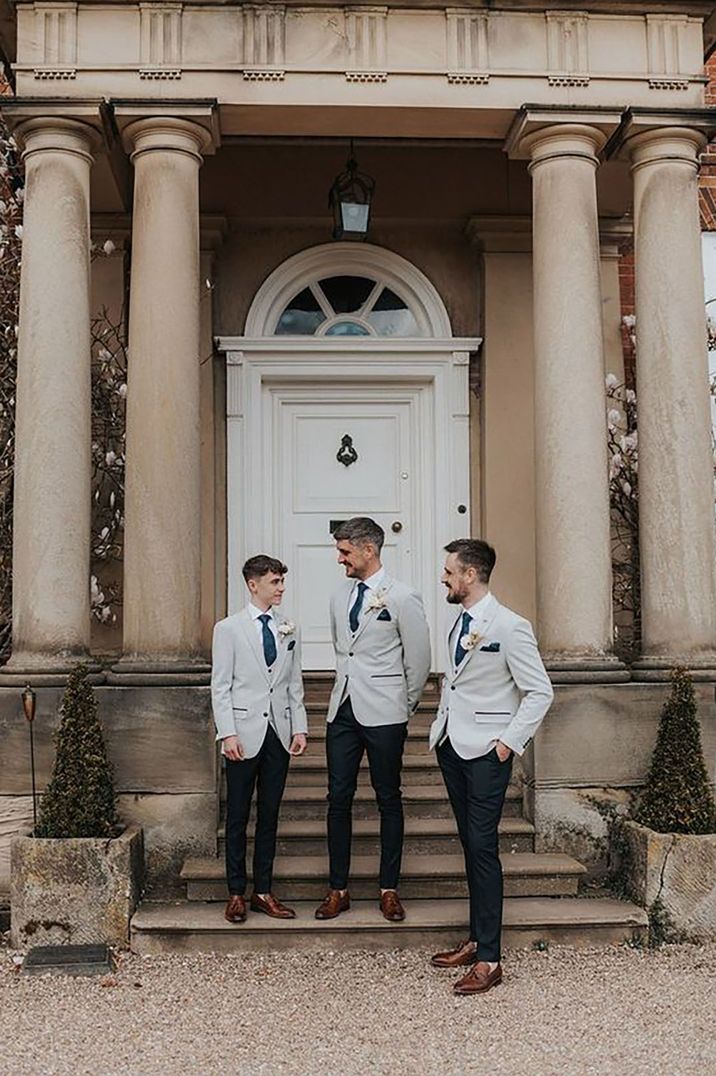 groom and groomsmen wearing matching light grey wedding suits