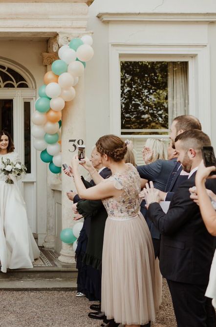 Balloon Installation Wrapped Around The Pillars of The Wedding Venue Entrance