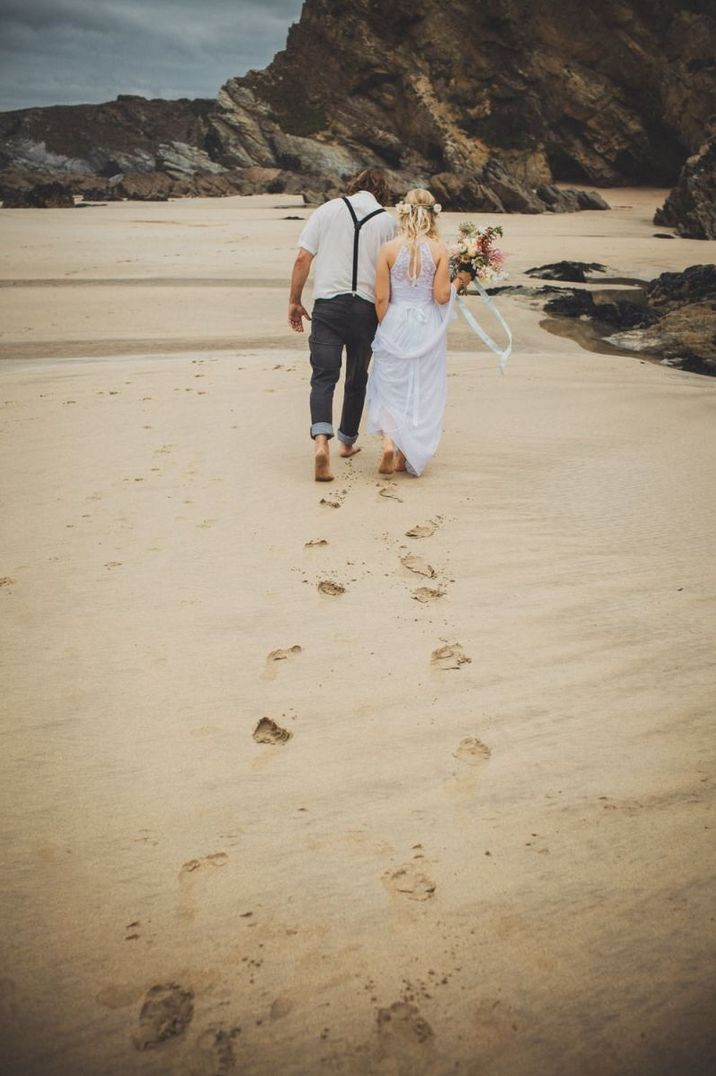 Bride and groom leaving footprints in the sand