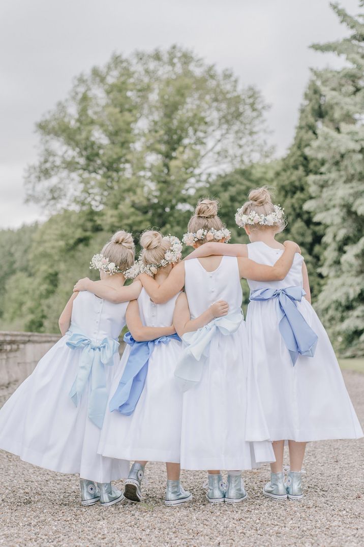 Traditional white dresses with blue sashes and converse trainers