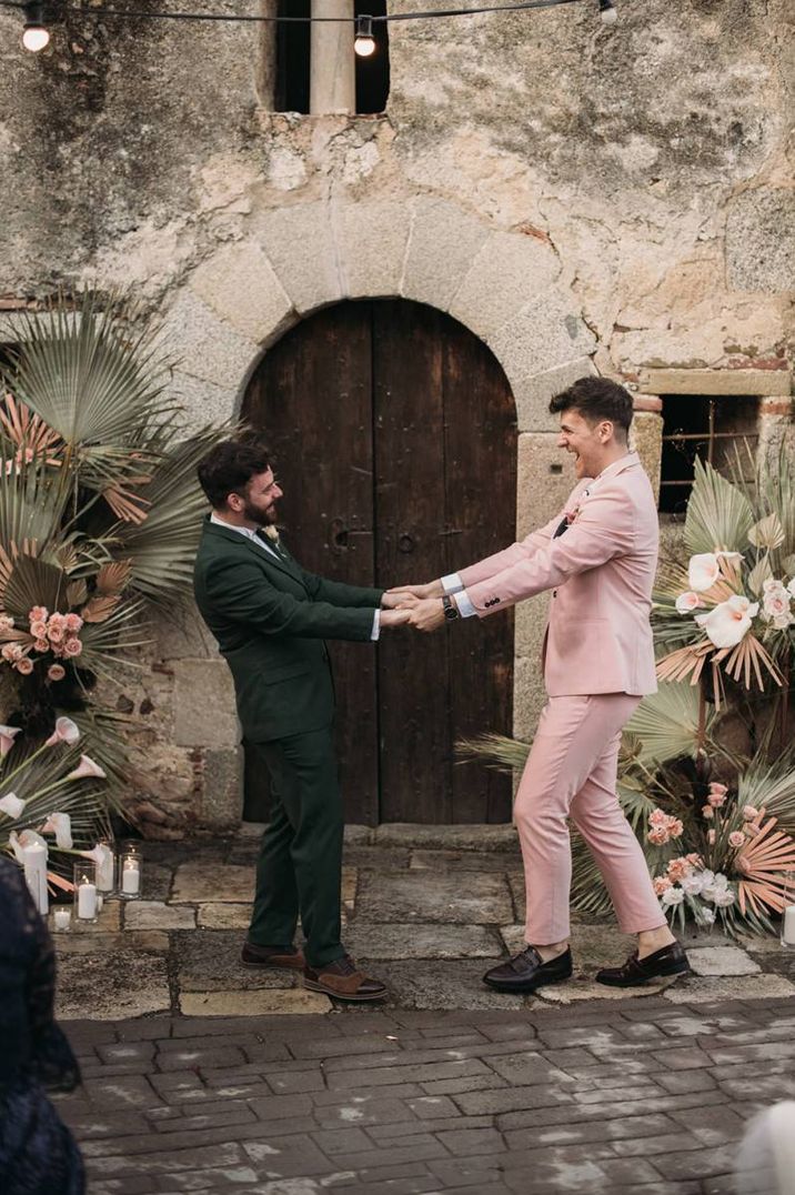 Gay wedding with grooms in pink and green wedding suits